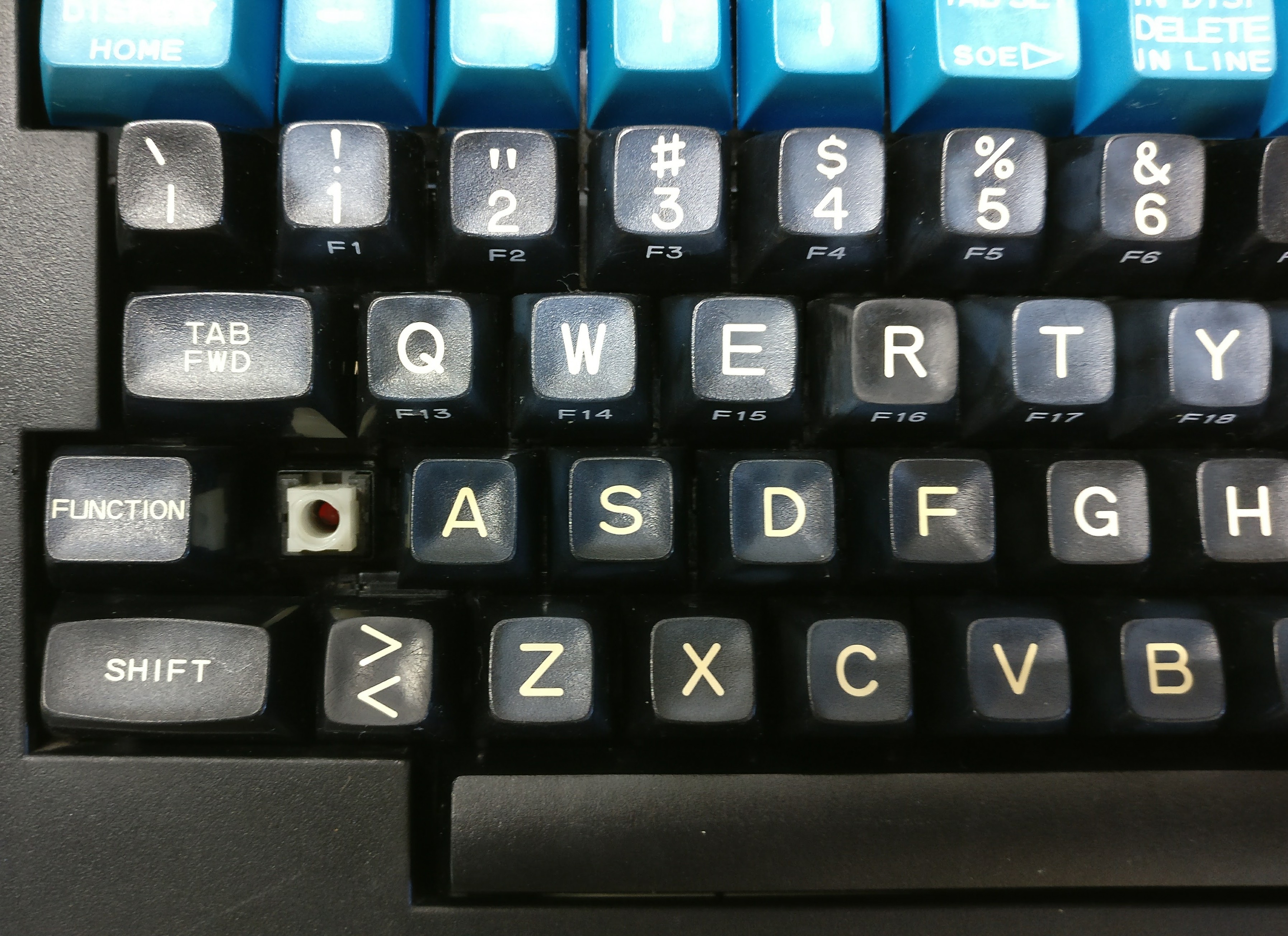 Key contrast: Q, R, and &gt;&lt; are a little lighter.