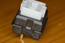 Assembled switch showing the Omron brand and keycap mount